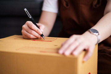 New house, asian woman wrighting on the boxes while feeling proud and excited about buying a house...