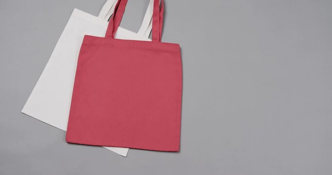 Close up of white and red bags on grey background, with copy space, slow motion