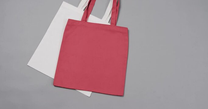 Close up of white and red bags on grey background, with copy space, slow motion