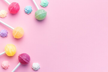 Sweet lollipops and candies on pink background