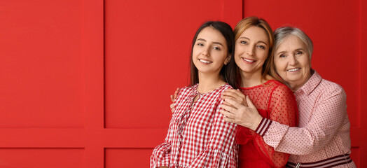 Portrait of happy mature woman with her daughter and mother on red background with space for text