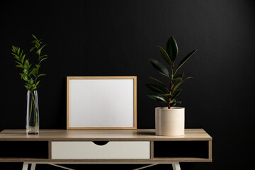Wood empty frame with copy space and plants in pots against black wall