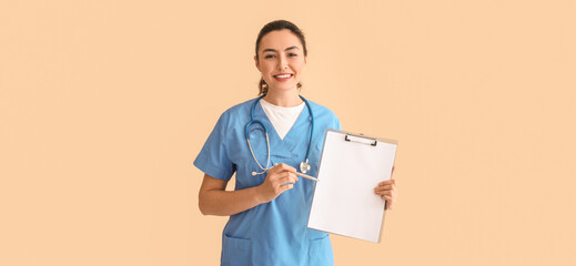Female medical assistant with clipboard on beige background