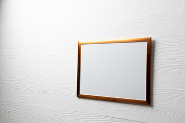 Brown empty frame with copy space on white wall