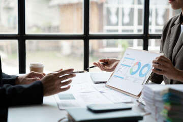 Accounting consultant, businesswoman meeting to discuss and clarify details on chart And data charts showing earnings, financial reports, income, taxes in the meeting room in the office.