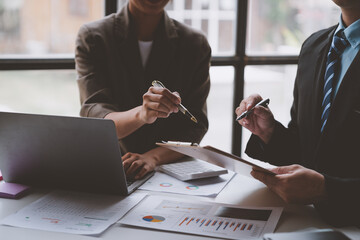 Team of business people working at office. Analyzing, discussing and recording financial budget results, investments, project plans, business operations based on graph documents. chart into laptop.