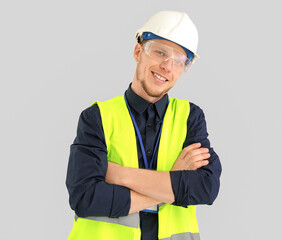 Male worker in vest and hardhat on grey background