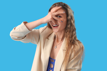 Fototapeta premium Beautiful young woman in jacket on blue background