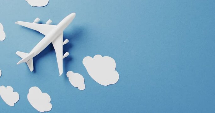 White plane model and white clouds with copy space on blue background