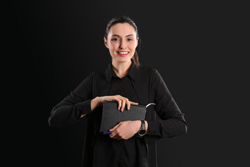 Female business consultant with notebooks on dark background