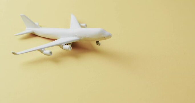 Close up of white airplane model and copy space on yellow background