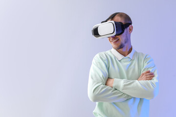 Young man using VR glasses on light background