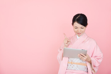 タブレットを操作する着物を着た女性