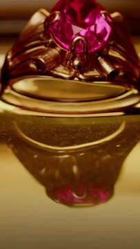 a golden ring with a red stone appears from the golden water macro frame