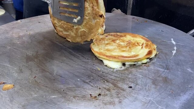 Egg roll making in street side in India. Calcutta-style egg roll is a popular snack, where a paratha is stuffed with egg, sometimes with vegetables, chicken or mutton kabab