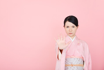 手を出して制止する着物を着た女性