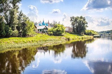 Fototapeta na wymiar Cathedral of the Annunciation with blue domes and houses with reflection in the Klyazma river, Gorokhovets