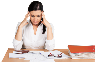 Frustrated businesswoman sitting at the table with many papers in office