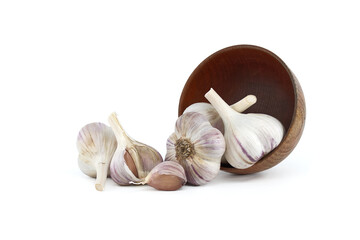 Garlic bulbs spilling from wooden bowl on white