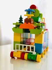 A colorful block toy house on wheels