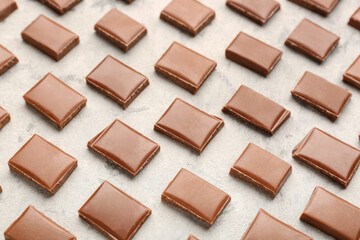 Composition with pieces of tasty chocolate on light background