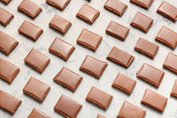 Composition with pieces of tasty chocolate on light background