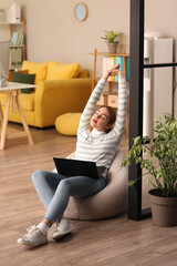 Female programmer with laptop stretching in office