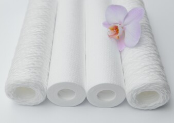 Cartridges for water treatment systems on white background.