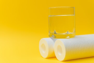 Cartridges for water treatment systems on yellow background.