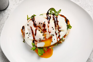Plate with delicious egg Benedict on white table, closeup