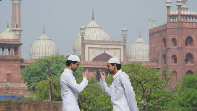 Young Muslim men doing adab to each other as greeting at a mosque