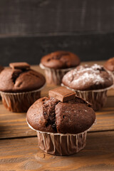 Tasty chocolate cupcakes on wooden table