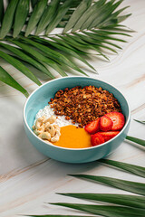 Portion of breakfast muesli bowl with strawberries and cashew