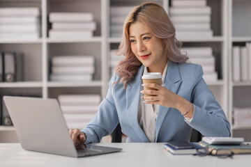 Portrait of Asian business woman holding coffee cup with work in workplace office Business documents money financial planning concept