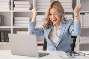 Excited happy woman looking at the laptop computer screen, celebrating an online win, overjoyed young asian female screaming with joy, isolated over a white blur background
