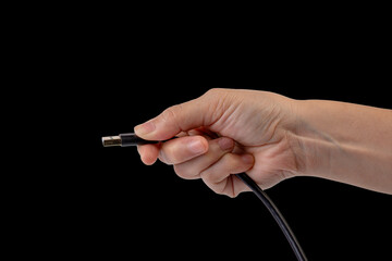 Hand and usb cable isolated on black background 