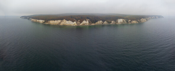 panoramic drone shot of the chalk cliffs of Rügen , Germany in foggy autumn weather with the Baltic Sea in foreground