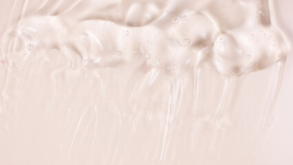 Pink clear skincare cream with bubbles background. Transparent colored cosmetic product close up