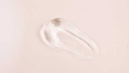 Cosmetic product swatch moisturizing lotion isolated on pink background, squeezed out and smeared portion of skincare cream product testing