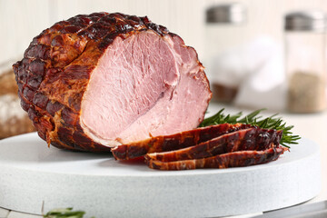 Board with tasty smoked ham on white wooden background