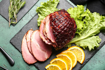 Board with tasty smoked ham on green grunge background