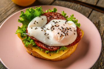 Plate with tasty egg Benedict on wooden background, closeup