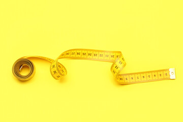 New measuring tape on yellow background