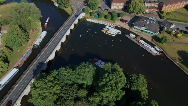 Aerial view dolly shot across vehicles driving on Clapton historical archway canal bridge, England