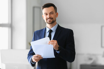Handsome businessman with documents working in office