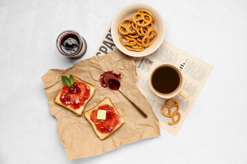 Tasty toasts with cranberry jam, cup of coffee and cookies on light background