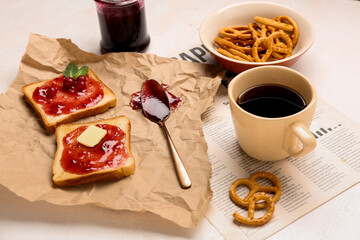Tasty toasts with cranberry jam and cup of coffee on light background