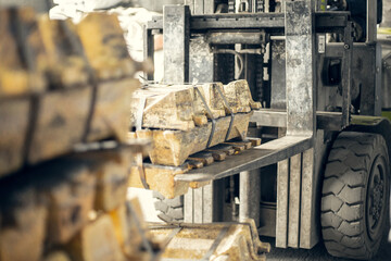 loader lifts a stack of brass ingots in a casting factory