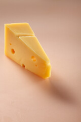 Piece of cheese on orange color background.