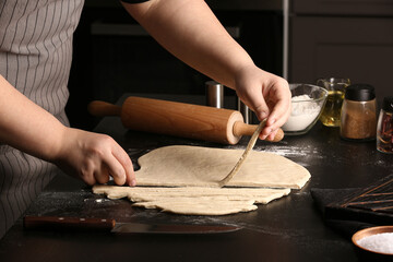Fototapeta na wymiar Woman preparing Italian Grissini at table in kitchen, closeup
